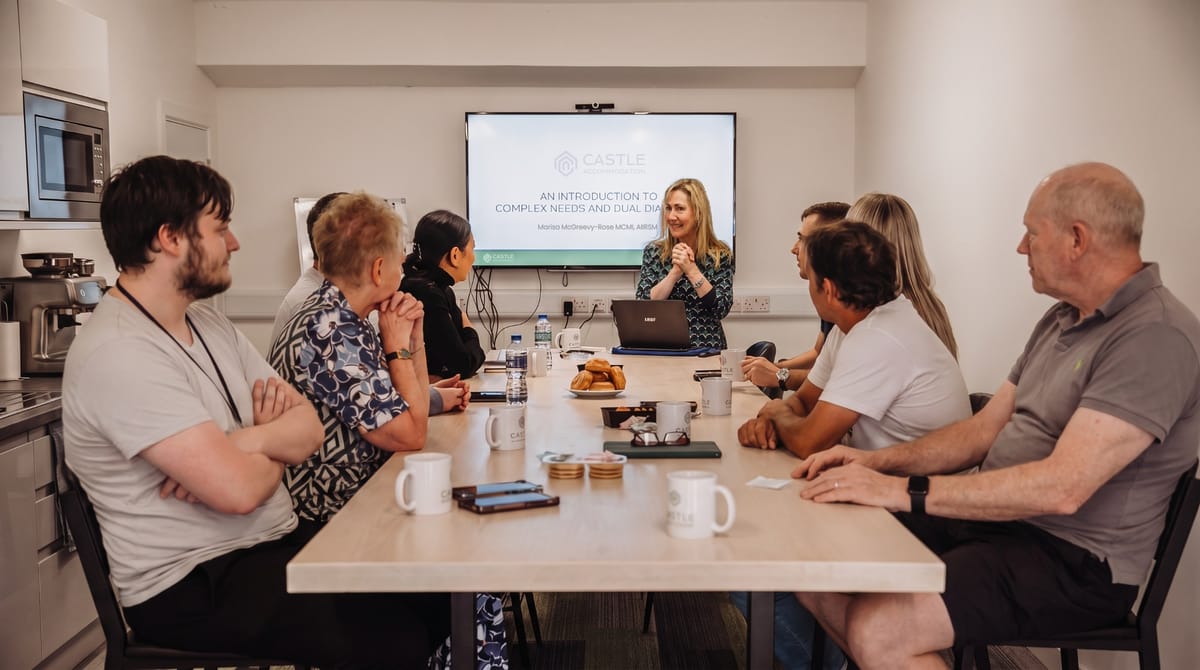 Our team at a training session around a meeting table, with a presentation on the screen